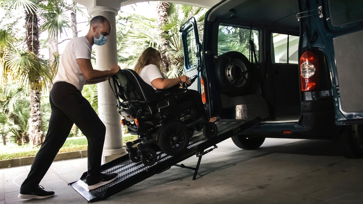 Disabled person on wheelchair using van ramp